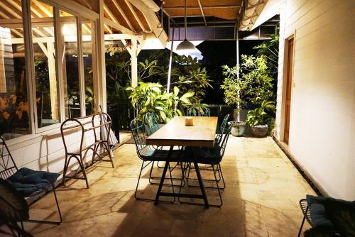 une table et des chaises sur une terrasse avec des plantes dans l'établissement 3 Bedroom Villa with Private Pool in Berawa, à Canggu