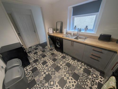 a bathroom with a sink and a counter with a floor at Comfortable 3 Bedroom House with Easy City Access in Swansea