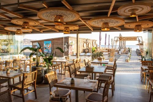 a restaurant with tables and chairs and a view of the ocean at Yianna Caravel Suites "by Checkin" adults only in Amoudara Herakliou