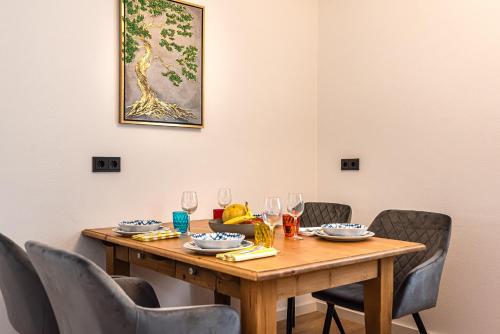 a wooden table with chairs around it with wine glasses at Im Grasweg - Just 7 Minutes From MUC Airport in Neufahrn bei Freising
