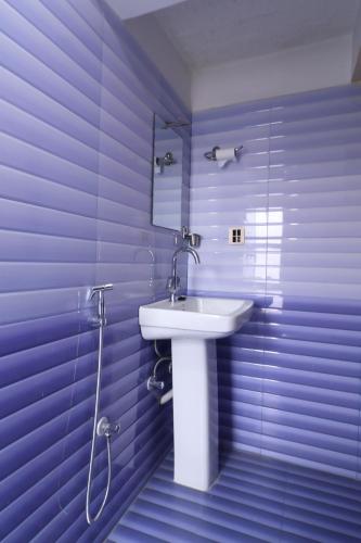 a bathroom with a white sink and purple walls at Hotel Kiba Nanee in Bhaktapur