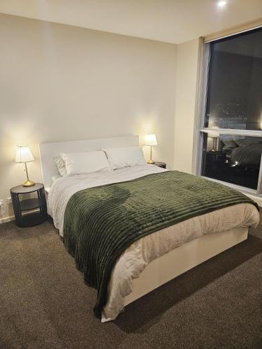 a bedroom with a large bed and a window at The Metropolitan Apartments in Canberra
