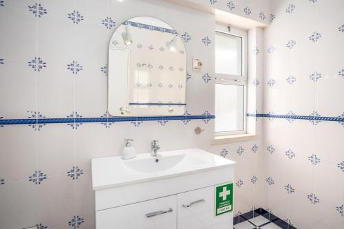 a bathroom with a sink and a mirror at Charming Flat with Balcony - Portimão by HostWise in Portimão