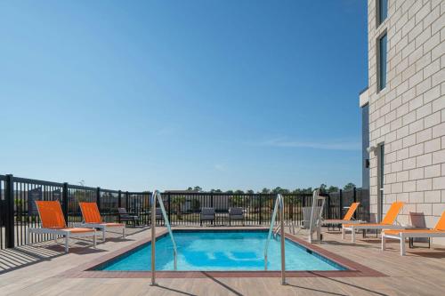 a swimming pool on a balcony with lounge chairs at Aloft Katy Mills in Katy