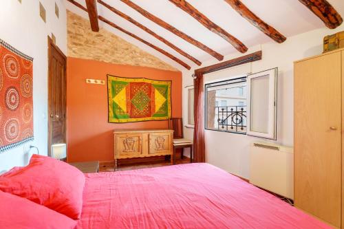 a bedroom with a pink bed and a window at La Casica del Sol in Requena