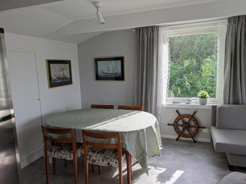 a dining room with a table and chairs and a window at Cozy apartment near salty baths! in Uddevalla