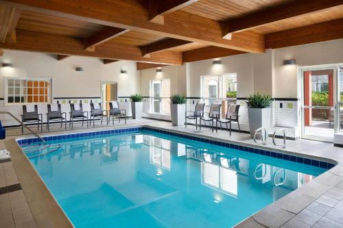 a swimming pool in a house with chairs at Fairfield by Marriott Inn & Suites Denver Airport in Denver