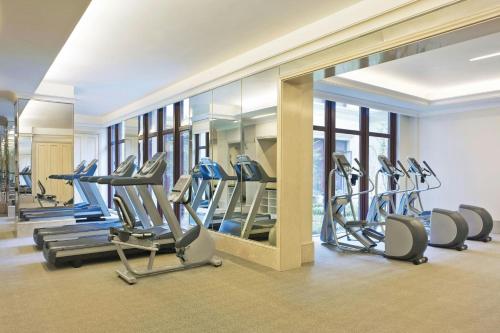 a gym with a row of tread machines and a mirror at The Westin Zhujiajian Resort, Zhoushan in Zhoushan