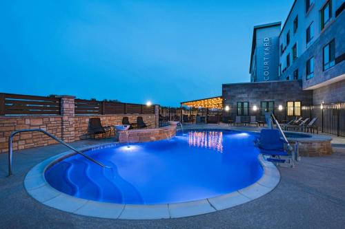 a large swimming pool in the middle of a building at Courtyard Dallas Grand Prairie in Grand Prairie