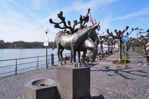 a statue of a horse on a sidewalk next to the water at Altstadtappartement Königswinter in Königswinter
