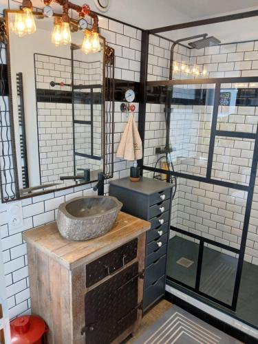 a bathroom with a sink on a counter at Chambre " Nid Cosy " Charme et Détente chez Fred in Gorron
