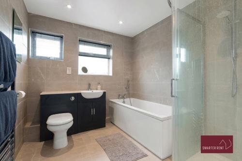 Un baño con bañera, inodoro y ducha. en Holyport - Three Bedroom House - Parking, en Maidenhead