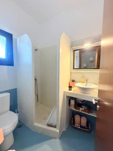 a bathroom with a shower and a sink and a toilet at Sunset Apartments in Gourna