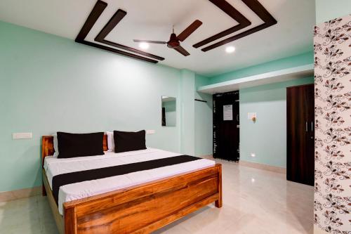a bedroom with a bed and a ceiling fan at Hotel O Kanak Stays in Bhubaneshwar