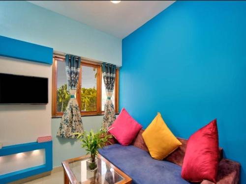 a living room with a purple couch with colorful pillows at Villa platinum 4 BHK Calangute in Calangute