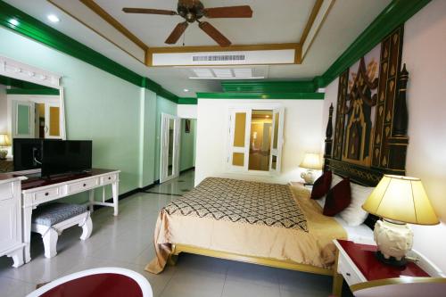 a bedroom with a bed and a desk and a television at Le Ayodhaya Palace Krabi Beach Resort in Krabi town