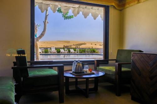 Una habitación con una mesa y sillas y una ventana grande. en The Golden Sand Resort&Camp, en Jaisalmer