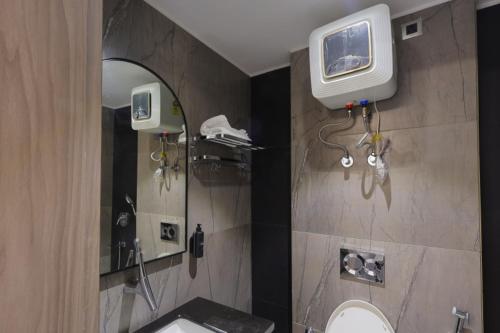 a bathroom with a sink and a tv on the wall at Hotel Vintage Villas in New Delhi