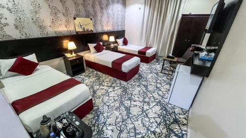 a hotel room with two beds and a desk at فندق اركان المطاف توصيل مجاني للحرم in Makkah