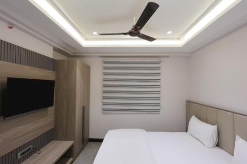 a bedroom with a bed and a ceiling fan at Hotel Vintage Villas in New Delhi