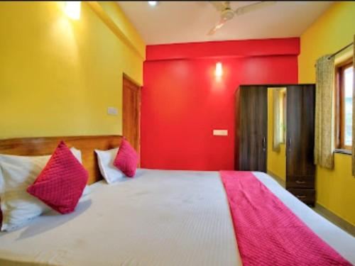 a bedroom with a large bed with red walls at Villa platinum 4 BHK Calangute in Calangute