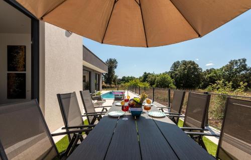 a wooden table with an umbrella on a patio at Stunning Home In Zaton in Zaton