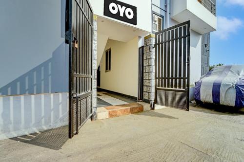 an entrance to a building with an open gate at Hotel O MM Home Stays in Irugūr