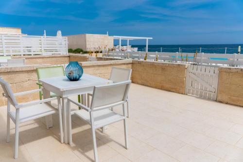a table with two chairs and a vase on a balcony at Hotel La Sorgente in Savelletri di Fasano