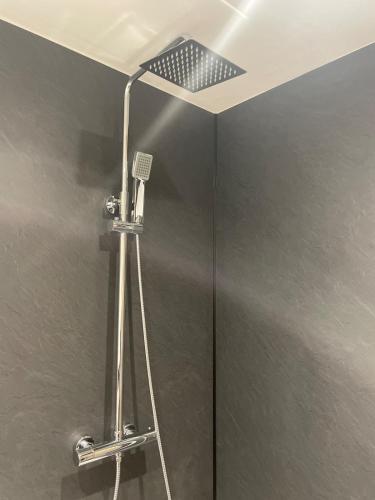 a shower with a light on the ceiling at 2 bedroom country cottage in the Lake District in Penrith