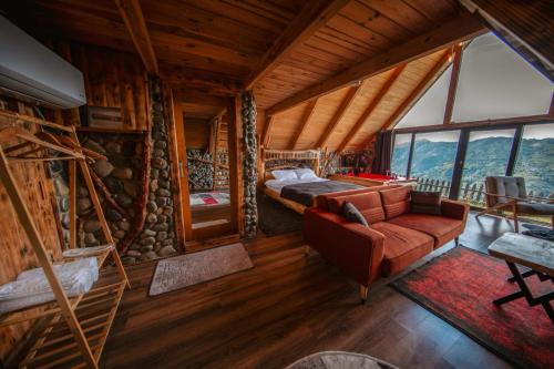 a bedroom with a bed and a couch in a room at Livoz Suit Bungalov in Çayırdüzü