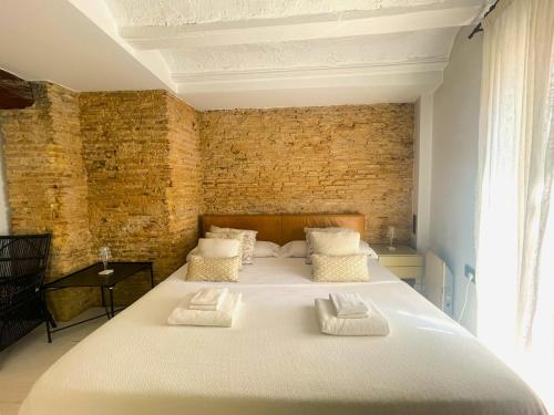 ein großes Bett in einem Zimmer mit Ziegelwand in der Unterkunft Valencia Luxury - Boutique El Carmen in Valencia