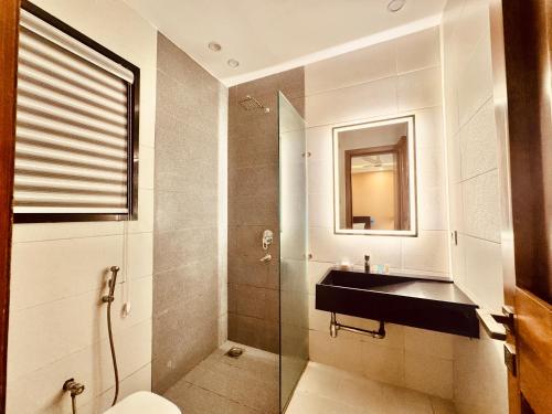 a bathroom with a glass shower and a sink at The Cozy Suite by Lux Haven Stays 2 Bedroom Apartment in Lahore