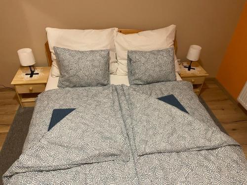 a bed with two pillows and a blanket on it at Napocska Nyaralóház Keszthely in Keszthely