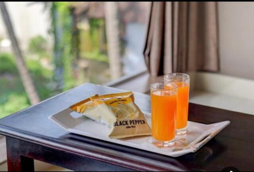 a table with a plate of food and a glass of orange juice at Hotel 4 Season in Vadodara