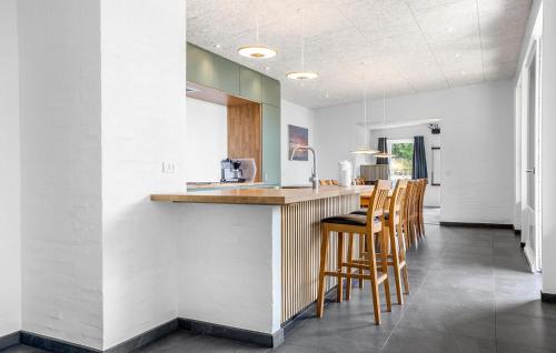 a kitchen with wooden bar stools and a counter at Awesome Home In Spøttrup With Wifi in Lihme