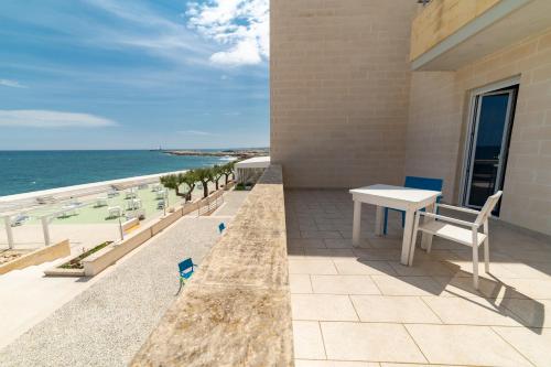 a balcony with a table and chairs and the ocean at Hotel La Sorgente in Savelletri di Fasano