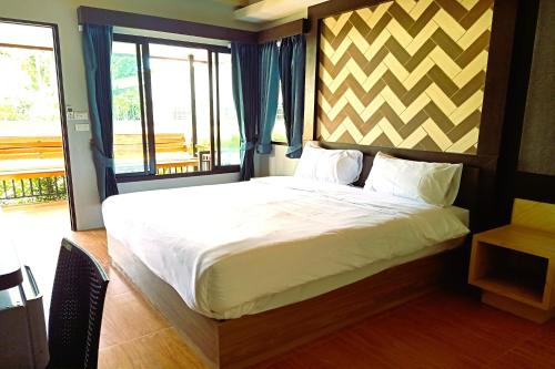 a bedroom with a large bed and a window at Resort Thalang in Phuket