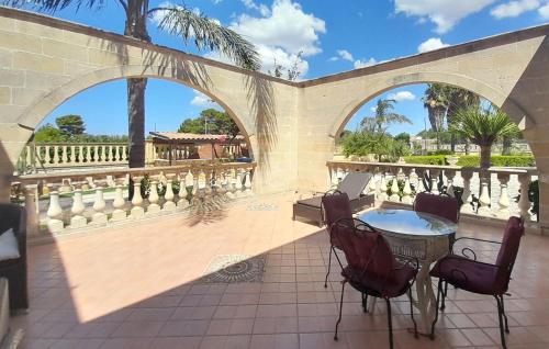 a patio with two arches and a table and chairs at Lovely Apartment In Torricella With Wifi in Torricella