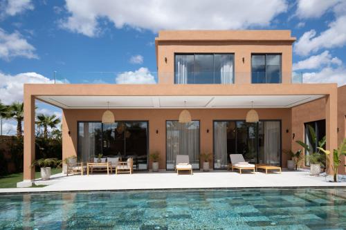 a villa with a swimming pool in front of it at Domaine de Kali, villa 2 au calme, piscine privée in Marrakech