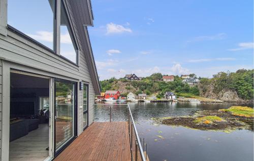 a house with a wooden dock next to a body of water at Amazing Home In Bremnes With Wifi in Bremnes