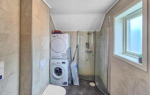 a bathroom with a washing machine and a shower at Amazing Home In Bremnes With Wifi in Bremnes