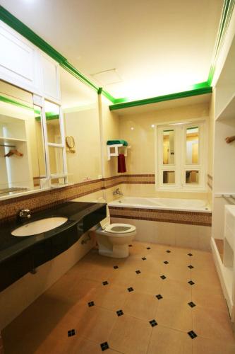 a bathroom with a toilet and a sink and a tub at Le Ayodhaya Palace Krabi Beach Resort in Krabi town