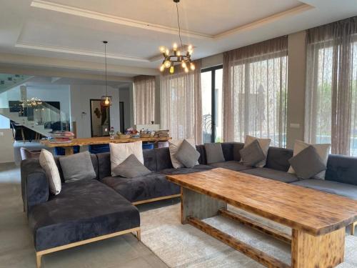 a living room with a couch and a wooden table at Domaine de Kali, villa 2 au calme, piscine privée in Marrakech