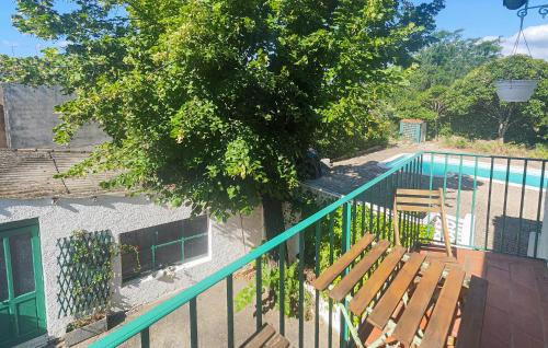 una recinzione con due panchine di legno accanto a un albero di Awesome Home In Thézan Les Béziers a Thèzan-lès-Béziers