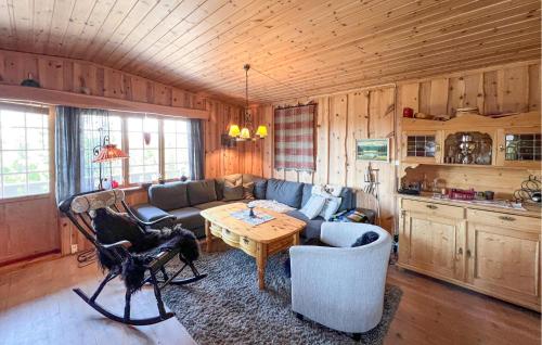 una sala de estar con un sofá y una mesa en Beautiful Home In Sjusjøen With Sauna, en Sjusjøen
