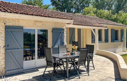 un patio con tavolo e sedie di fronte a una casa di Maison Avec Piscine Et Etang a Tournon-dʼAgenais