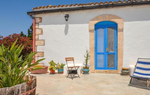 a blue door on a house with chairs and plants at Stunning Home In Marzamemi With Wifi in Marzamemi
