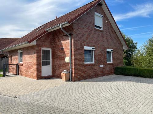 a red brick house with a large driveway at Skippersin5 in Greetsiel