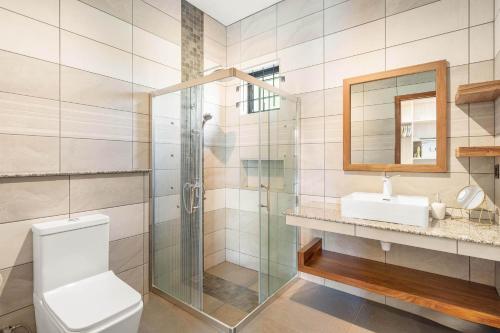 a bathroom with a shower and a toilet and a sink at L'écrin de la Preneuse, villa avec piscine privée proche de la plage in Rivière Noire