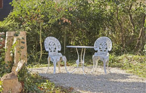 two metal chairs and a table in a garden at Awesome Home In Humble With Wifi in Humble